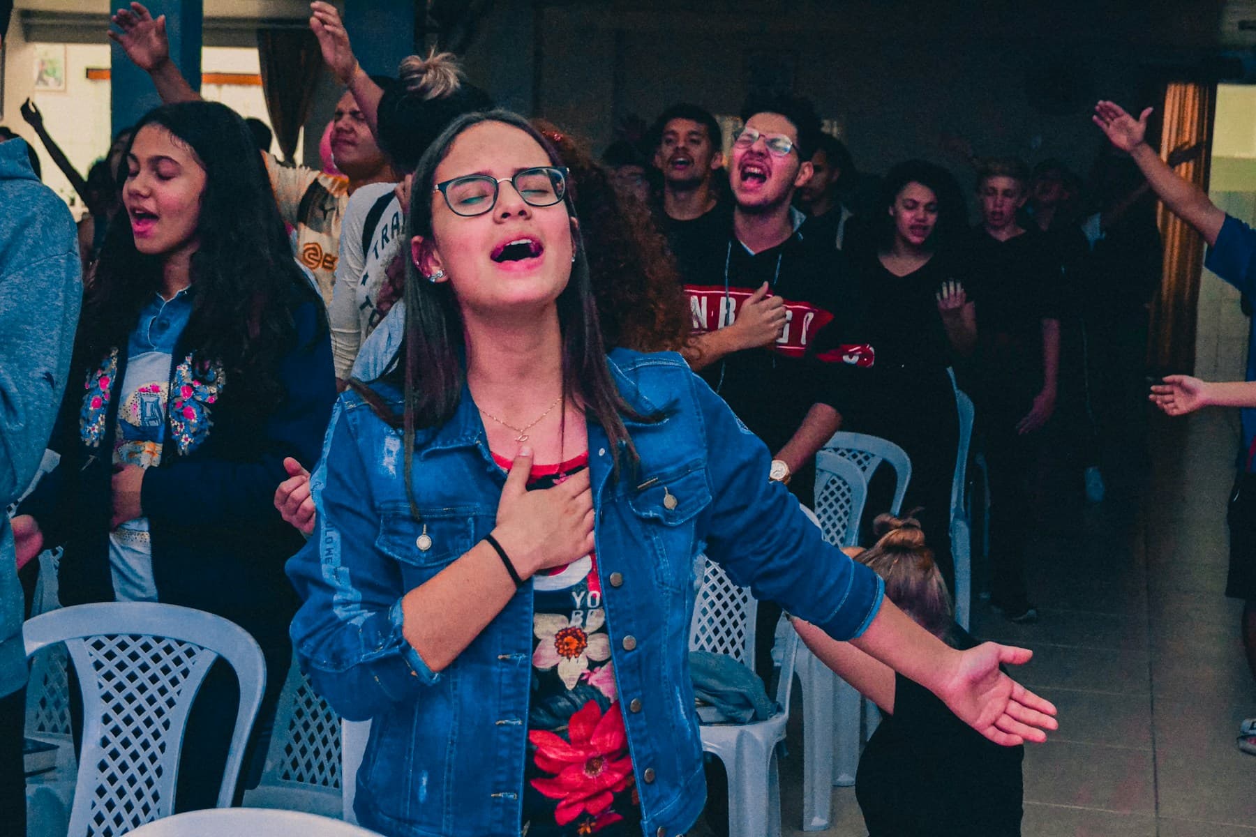 Jovens em momento de louvor numa igreja